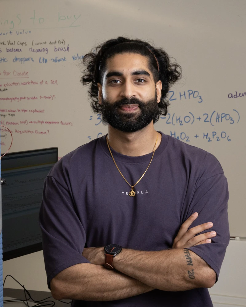Ishaan Madan standing in front of a chemistry whiteboard.